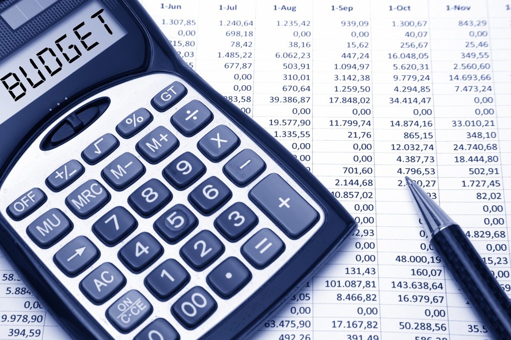 Calculator displaying 'BUDGET' on financial spreadsheet, symbolizing budgeting and expense planning
